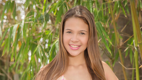 Sweet little Kiara Lorens happily shows off her teen pussy in the woods